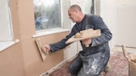 Applying The finishing coat of plaster on top of the plasterboard